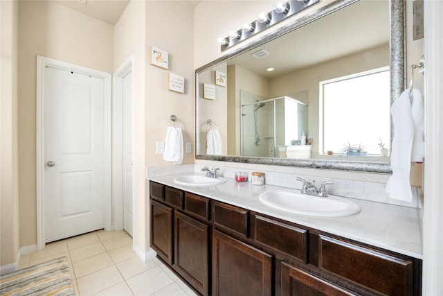 bathroom featuring a shower with door, vanity, and tile patterned flooring