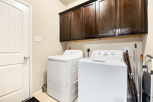 washroom featuring washer and dryer, cabinets, and light tile patterned floors