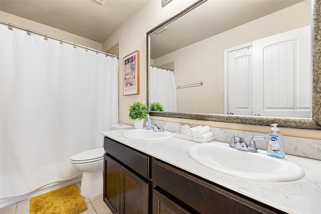 bathroom with toilet, vanity, and tile patterned floors