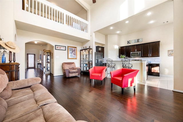 living room featuring a towering ceiling and hardwood / wood-style floors