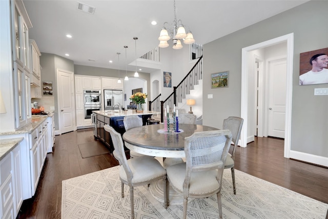 dining space featuring sink, dark hardwood / wood-style floors, and an inviting chandelier