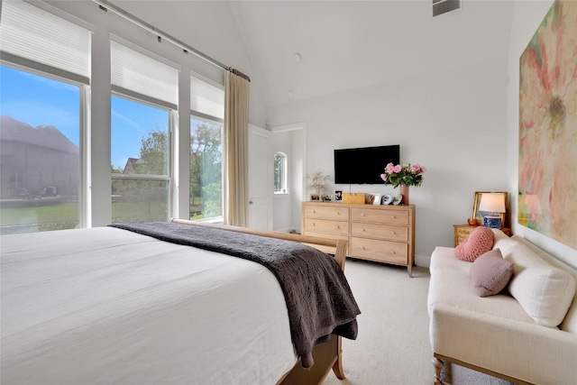 carpeted bedroom featuring multiple windows and high vaulted ceiling