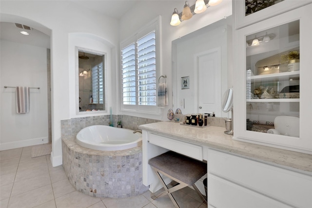 bathroom with vanity, tiled bath, and tile patterned floors