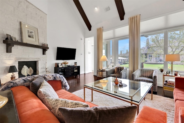 living room featuring lofted ceiling with beams, a fireplace, dark hardwood / wood-style floors, and plenty of natural light