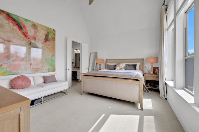 carpeted bedroom with ceiling fan, a towering ceiling, and connected bathroom