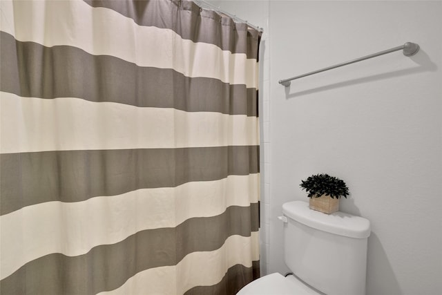 bathroom featuring a shower with shower curtain and toilet