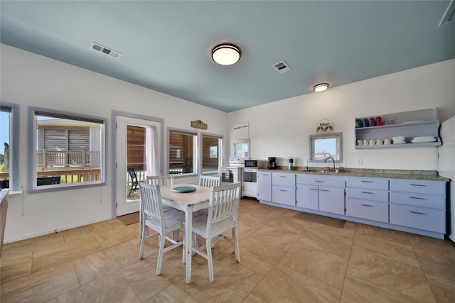 dining space with light tile patterned floors and sink