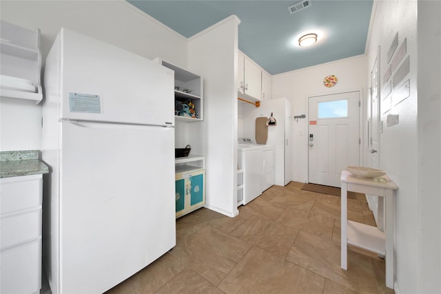 kitchen with white cabinets, separate washer and dryer, and white fridge