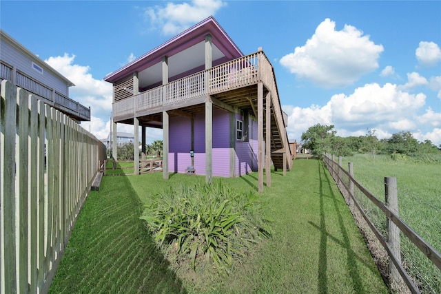 back of house featuring a lawn and a deck