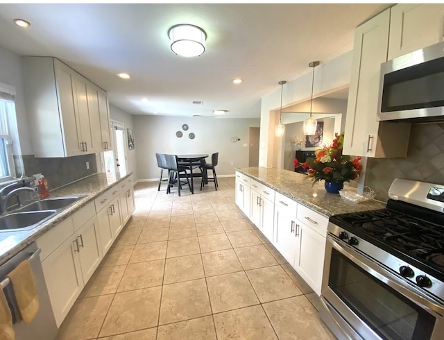 kitchen with white cabinets, decorative light fixtures, stainless steel appliances, and sink