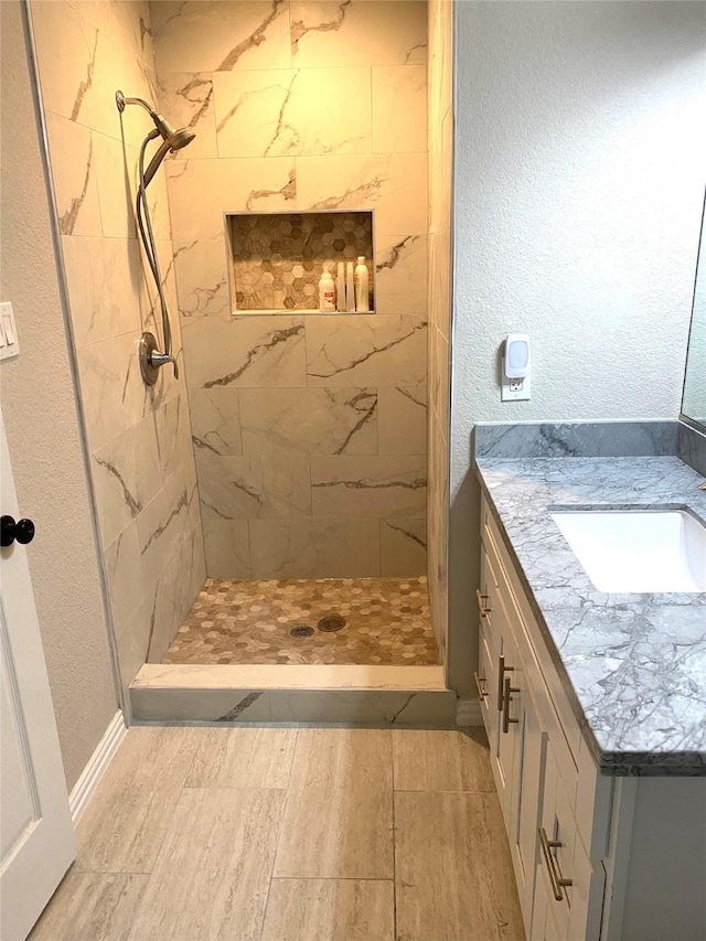 bathroom with vanity and a tile shower