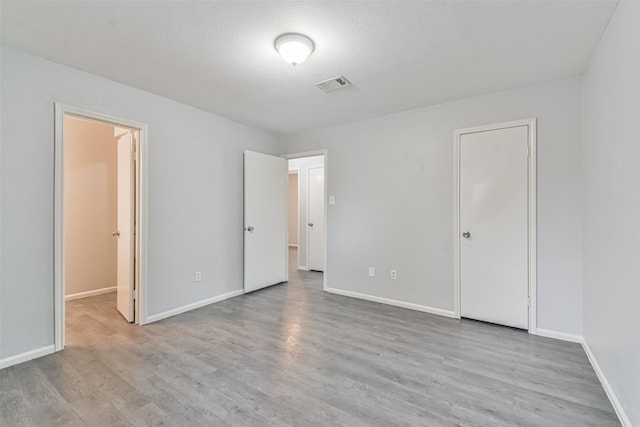 unfurnished bedroom featuring a textured ceiling and light wood-type flooring