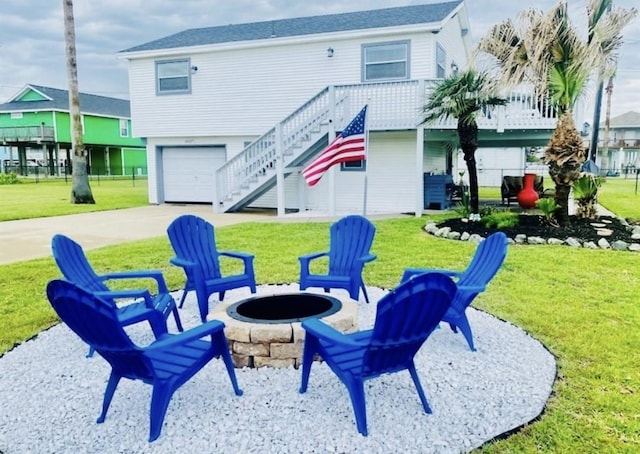 exterior space featuring a garage, a yard, and an outdoor fire pit