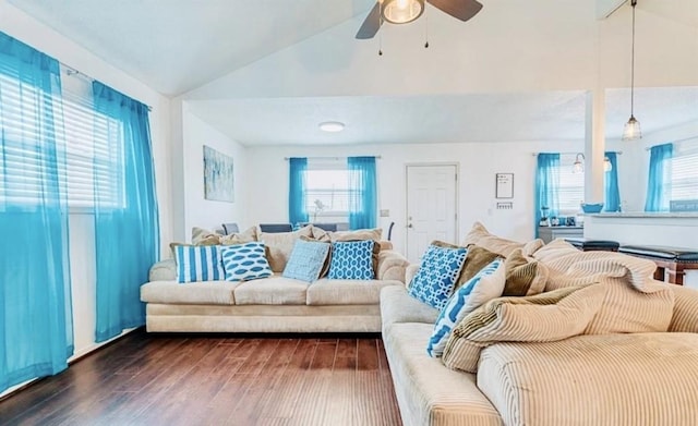 living room with a healthy amount of sunlight, dark hardwood / wood-style flooring, and lofted ceiling