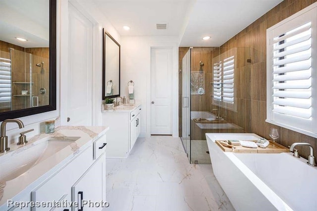 bathroom with visible vents, marble finish floor, a stall shower, a sink, and a freestanding bath