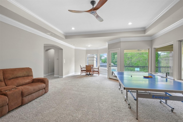 game room with ceiling fan, a raised ceiling, ornamental molding, and light carpet