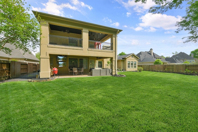 back of house featuring a lawn, a patio area, and a balcony