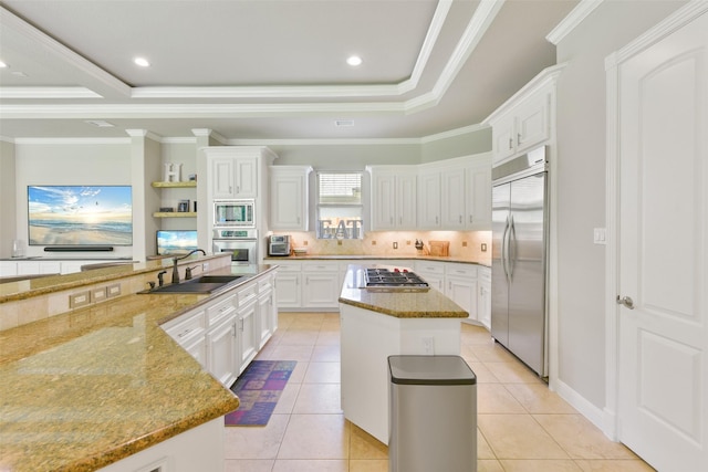 kitchen with white cabinetry, sink, light stone counters, built in appliances, and a kitchen island