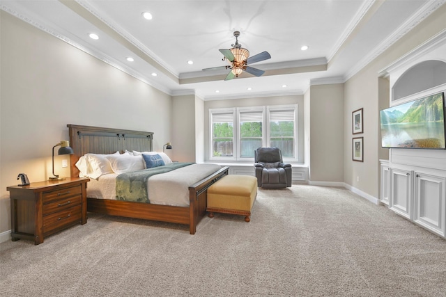 carpeted bedroom featuring a tray ceiling, ceiling fan, and crown molding