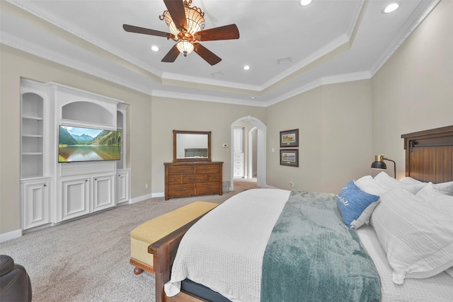 carpeted bedroom featuring ceiling fan, ornamental molding, and a tray ceiling