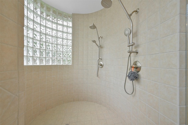 bathroom with a tile shower and a wealth of natural light