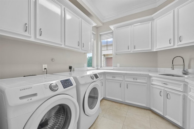 washroom featuring cabinets, crown molding, sink, separate washer and dryer, and light tile patterned floors