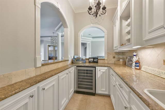 kitchen featuring light stone counters, white cabinetry, and wine cooler