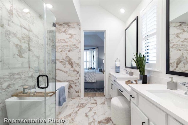 bathroom with tile walls, vanity, vaulted ceiling, and separate shower and tub