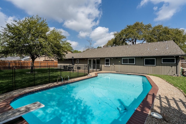 view of pool featuring a diving board and a lawn