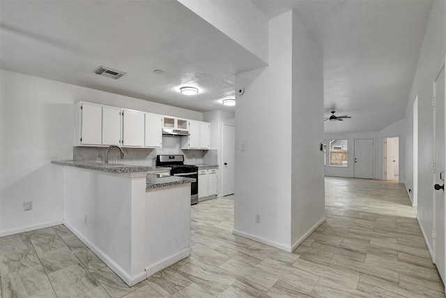 kitchen with tasteful backsplash, ceiling fan, sink, stainless steel range oven, and white cabinetry