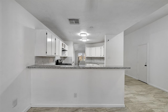 kitchen featuring backsplash, kitchen peninsula, white cabinets, and black / electric stove