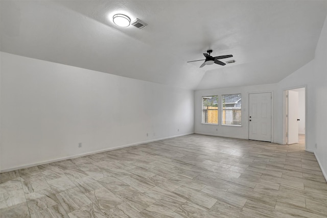 empty room with a textured ceiling, vaulted ceiling, and ceiling fan