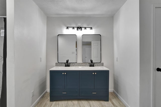 bathroom with vanity, wood-type flooring, and a textured ceiling