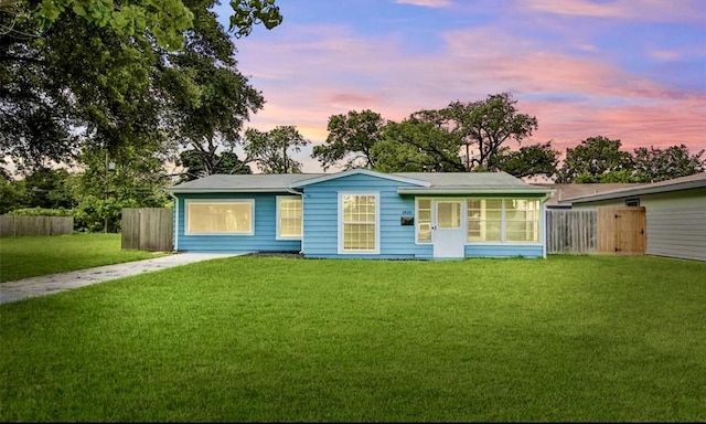 single story home featuring a lawn and a sunroom