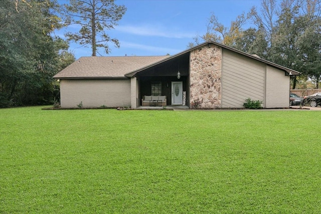 rear view of house featuring a lawn