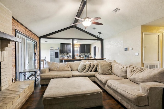 living room featuring lofted ceiling with beams, ceiling fan, dark hardwood / wood-style flooring, and a brick fireplace