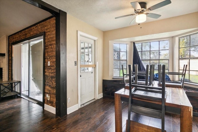 home office with a textured ceiling, dark hardwood / wood-style flooring, and ceiling fan