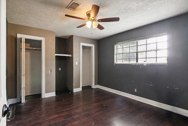 unfurnished bedroom featuring ceiling fan, dark hardwood / wood-style floors, a textured ceiling, and a closet