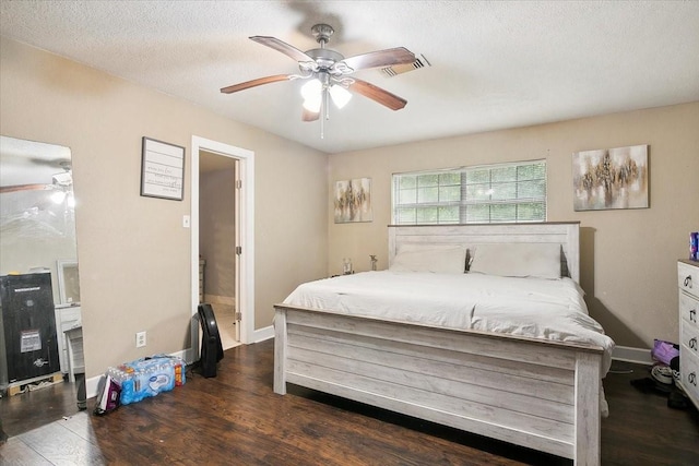 bedroom with a textured ceiling, dark hardwood / wood-style flooring, and ceiling fan