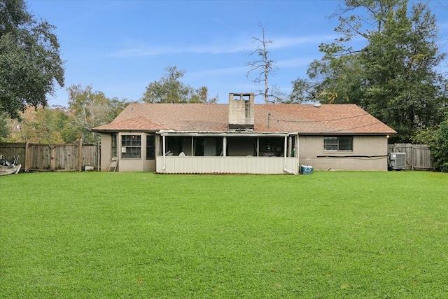 back of house featuring central AC unit, a lawn, and a sunroom