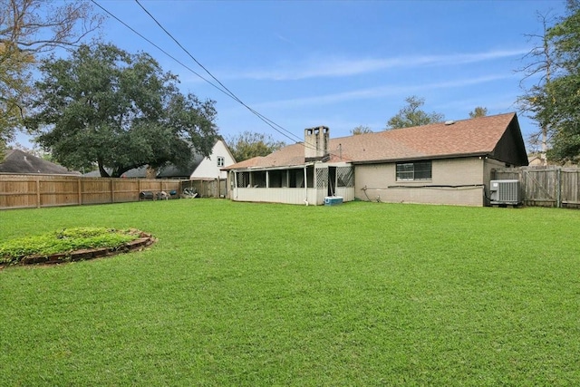 back of property featuring a sunroom, cooling unit, and a yard