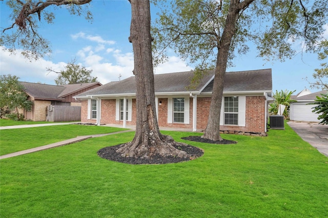 single story home with central AC unit, a front yard, and a garage