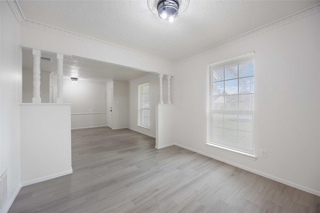 unfurnished room featuring light hardwood / wood-style flooring, a textured ceiling, and ornamental molding