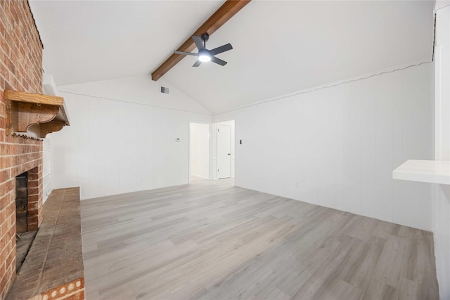 unfurnished living room featuring vaulted ceiling with beams, ceiling fan, light hardwood / wood-style floors, and a brick fireplace