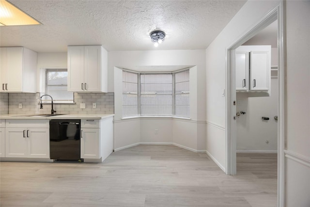 kitchen with dishwasher, white cabinets, tasteful backsplash, and sink