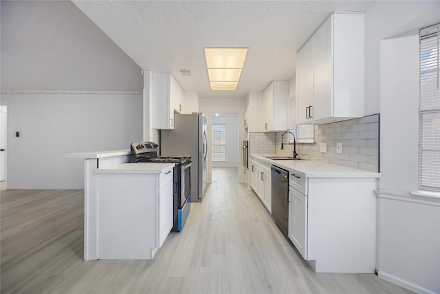 kitchen with backsplash, dishwashing machine, sink, white cabinetry, and stainless steel electric range