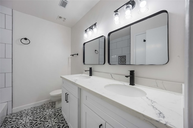 bathroom with tile patterned flooring, vanity, and toilet