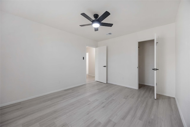 unfurnished bedroom with ceiling fan, light wood-type flooring, and a closet