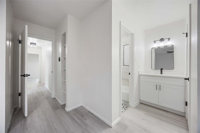 hall with sink and light hardwood / wood-style flooring