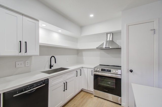 kitchen with dishwasher, stainless steel range with electric cooktop, sink, wall chimney exhaust hood, and white cabinetry